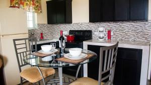 a kitchen with a glass table with chairs and a counter at Sunset Nabro in St Mary