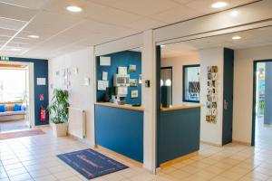 a lobby with a blue wall and a counter at Sev'hotel in Sévérac-le-Château