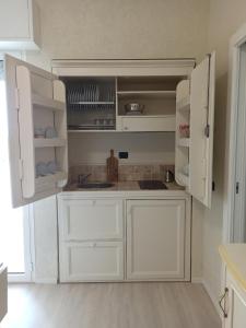 a kitchen with white cabinets and a sink at Hotel Mondial in Bellaria-Igea Marina