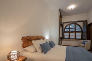 Schlafzimmer mit einem Bett und einem Fenster in der Unterkunft Escola do Fado in Vila Fernando