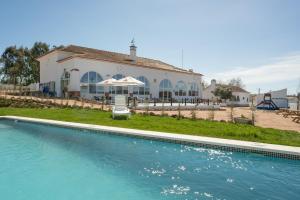 ein Haus mit einem Pool vor einem Haus in der Unterkunft Escola do Fado in Vila Fernando