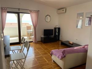 a bedroom with a bed and a living room with a balcony at Apartment Iris & Elena in Pinezici