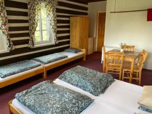 a room with three beds and a table and a dining room at Horská Chata Olympia in Josefŭv Dŭl