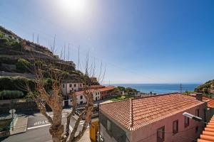 vistas a una calle con edificios y al océano en The Rum Inn, en Calheta