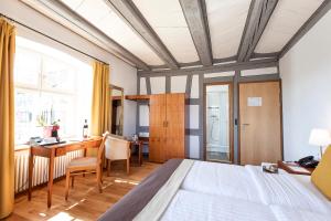 a bedroom with a bed and a desk and a table at Hotel de Charme Römerhof in Arbon