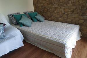 a bed with pillows on it in a room at Villa Terra da Eira T1 - Sun, Sea and Relax in Lourinhã +33 photos