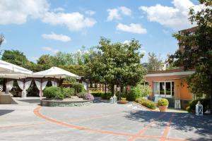 a courtyard of a building with trees and bushes at Montespina Park Hotel in Naples