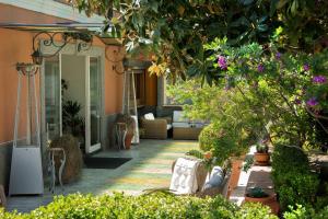 a porch with a swing in a house with flowers at Montespina Park Hotel in Naples