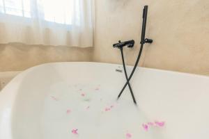 a bath tub with pink flowers on the floor at B&B Antico Telaio in Santa Maria Navarrese