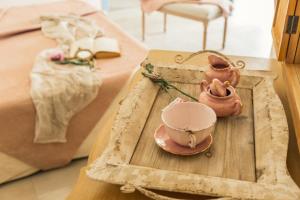 a tray with a tea pot and a tea set on a table at B&B Antico Telaio in Santa Maria Navarrese