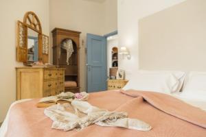 a bedroom with a bed with a book and a mirror at B&B Antico Telaio in Santa Maria Navarrese