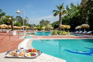 a tray of food on a table next to a swimming pool at Montespina Park Hotel in Naples