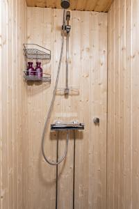 a bathroom with a shower in a wooden wall at Polar Aurora Cabins in Saariselka