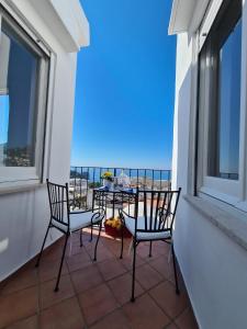 balkon z dwoma krzesłami i stołem w obiekcie Casa Leucosia Suites w mieście Capri