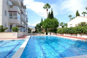 a swimming pool in front of a building at Apartamento Golf Pau Casals in Albir