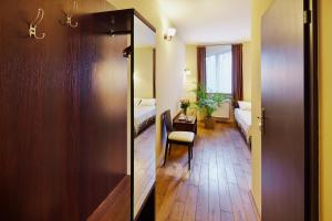 Cette chambre dispose d'un couloir avec un miroir et une table. dans l'établissement Medova Pechera, à Lviv