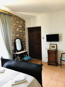 Schlafzimmer mit einem Bett, einem TV und einem Spiegel in der Unterkunft Relais Maffia B&B in Orsara di Puglia