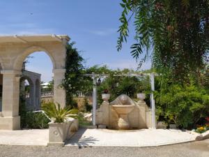 a fountain in a garden with an arch at B&B Tenuta Martinelli in Monopoli