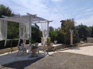 a white pergola with chairs and a table at B&B Tenuta Martinelli in Monopoli