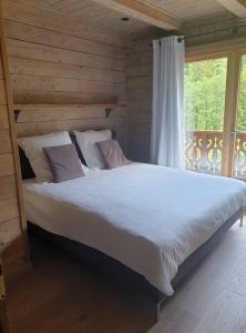a large bed in a room with a window at Chalet Les 5 Sapins in Les Allues