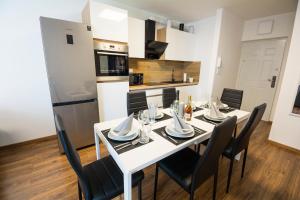 希歐福克的住宿－ÁbraApartman，厨房以及带白色桌椅的用餐室。