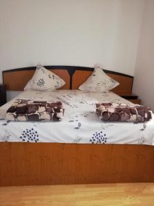 a bed with brown and white sheets and pillows at Casa Cleopatra 2 MAI in 2 Mai