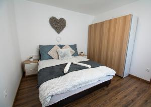a bedroom with a bed with a heart headboard at ÁbraApartman in Siófok
