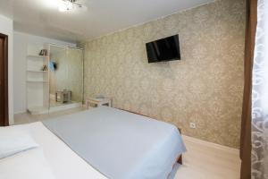 ヴォログダにあるФлагман 3のベッドルーム1室(ベッド1台、壁掛けテレビ付)