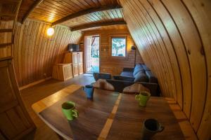 a living room with a table in a wooden room at Domki Nad Starą Regą in Mrzeżyno