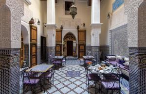 フェズにあるリヤド タルヤナの建物内のテーブルと椅子付きの部屋