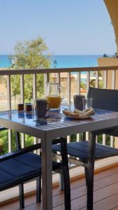 a table with a pitcher of juice on a deck at Studio standing classé avec terrasse vue mer " les pieds dans l'eau " à Algajola in Algajola