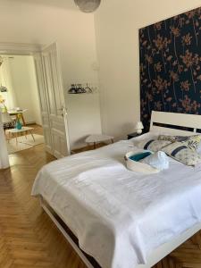 una camera da letto con un grande letto con lenzuola bianche e un muro di Villa Hortensia a Lubiana