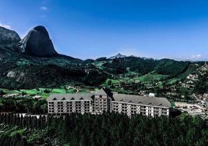 um grande edifício no topo de uma colina com montanhas em Condomínio Vista Azul Residencial Meeting Center em Domingos Martins