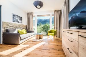 a living room with a large tv and a couch at Apartmenthotel Sonnenhof in Maria Alm am Steinernen Meer