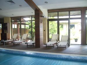 a row of lounge chairs in a swimming pool at Fortuna Apartments in Bansko