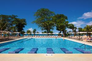 Riu Palace Tropical Bay - All Inclusive في نيغريل: مسبح كبير مع كراسي ومظلات