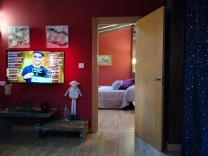 a room with a television and a bedroom with a bed at Posada Ormas in Ormas