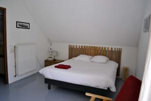 a bedroom with a white bed with a red towel on it at AUBERGE GAILLARD in La Motte-en-Champsaur