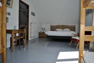 1 dormitorio con 1 cama, mesa y sillas en AUBERGE GAILLARD en La Motte-en-Champsaur