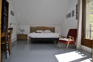 a bedroom with a bed and a chair at AUBERGE GAILLARD in La Motte-en-Champsaur