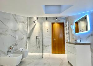 uma casa de banho com um chuveiro, um WC e um lavatório. em Primo Hotel em Tirana