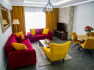 a living room with a red couch and yellow chairs at Onyx Luxury in Ulcinj
