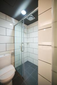 a bathroom with a toilet and a glass shower at Sense Hotel Taiping in Taiping