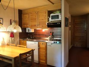 uma cozinha com um frigorífico branco e uma mesa em CHECK-IN CASAS Cerler 3F em Cerler