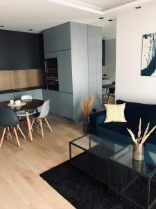 een woonkamer met een blauwe bank en een tafel bij Apartament Avior in Iława