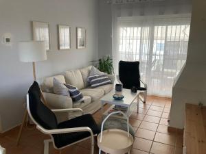 sala de estar con sofá, sillas y mesa en La Hacienda Golf Islantilla con Wifi y Aire Ac SOLO PAREJAS Y FAMILIAS, en Islantilla