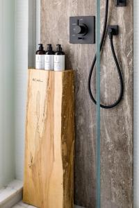a bathroom with a shower with four bottles of shampoo at 1 Hotel Toronto in Toronto