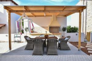 a patio with a wooden pergola and a table and chairs at Sea View Private Pool Villa Katrin in Gouves