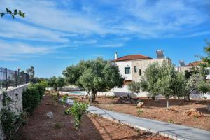 a garden with olive trees in front of a house at Sea View Private Pool Villa Katrin in Gouves