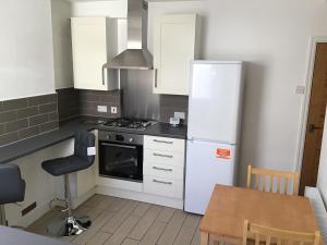 a kitchen with a white refrigerator and a table at Cosy end terrace in Lancaster